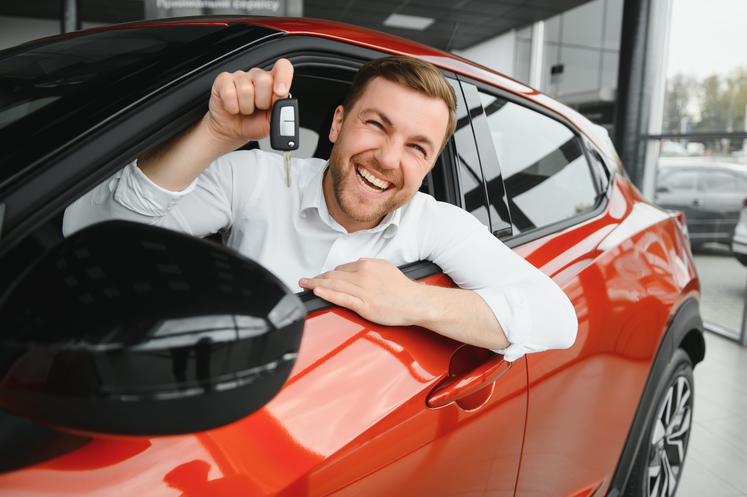 Happy man showing the key of his new car